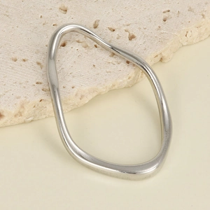 Close-up of irregular silver 304 stainless steel ring accessory on beige stone