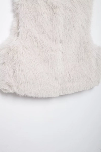Close-up of fluffy white faux fur vest texture showing soft material and detailed fibers