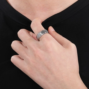 Close-up of a silver stainless steel grid ring with a single inset crystal on a finger