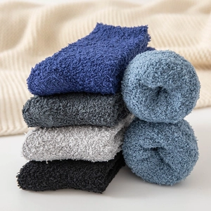 Detailed texture of thick coral fleece socks in multiple colors on beige knit background