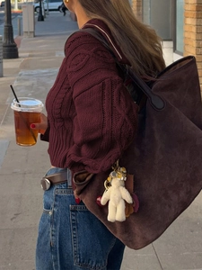 Primo piano di una grande borsa tote in pelle scamosciata marrone con ciondolo a peluche