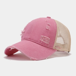 Close-up of distressed pink cotton twill and beige mesh on vintage baseball cap