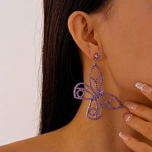 Close-up of purple butterfly crystal earrings worn on ear showing exquisite craftsmanship