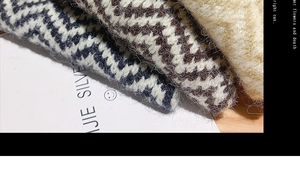 Close-up of knitted striped patterns showing the soft wool-blend fabric texture and weave