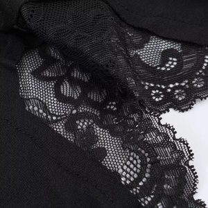 Détails de la dentelle noire complexe et de la texture en maille fine sur la robe
