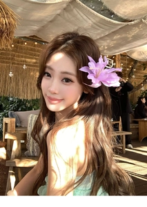 Detail of lavender fabric flower hair clip worn by a model in a romantic outdoor setting