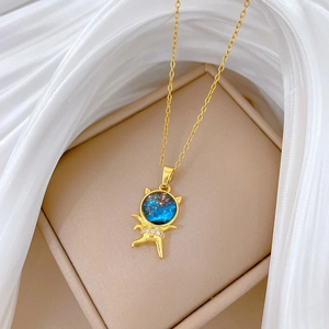 Close-up of golden astronaut necklace with star field pattern on white silk