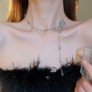 Macro detail of silver flower necklace with sparkling crystal tassels on model's neck