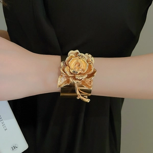 Statement gold open cuff bracelet featuring a large 3D metal rose with textured petals