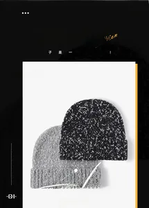 Close-up of black and grey thick knit beanies with speckled wool blend texture