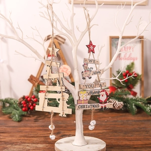 Christmas wooden tree ornaments with bells and festive lettering on a white decorative tree