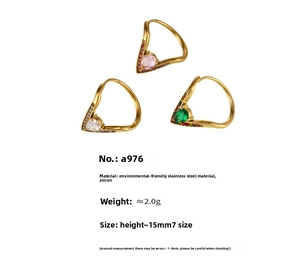 Détail de trois bagues en V dorées avec zircons poire en rose, blanc et vert émeraude