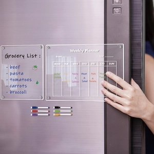 Macro view of clear magnetic acrylic weekly planner and grocery list with colorful markers