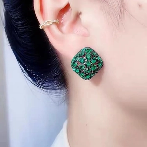 Elegant emerald green geometric diamond stud earrings and gold ear cuff on female ear