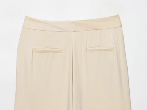 Détail du pantalon taille haute montrant les poches passepoilées dos et le tissu sergé