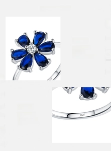 Macro detail of S925 sterling silver ring with blue zirconia petals and artisan setting