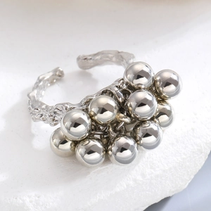 Detailed view of silver irregular spheres on a textured stone base for an open ring