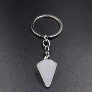 Detailed view of natural white crystal hexagonal cone pendant on silver keychain