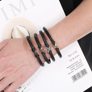Close-up of four woven leather bracelets with infinity symbols in different metal finishes