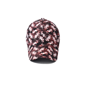 Detail of red and black abstract camouflage printed baseball cap with curved brim and button