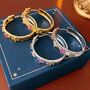 Vue détaillée de boucles d'oreilles en or 18 carats et argent sur un coffret cadeau