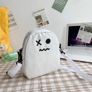 Détail du petit sac blanc à bandoulière avec motif cartoon sur tissu à carreaux