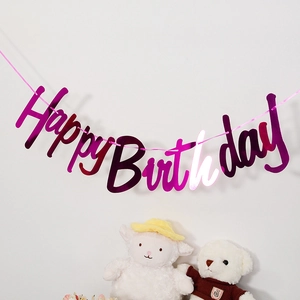 Metallic magenta Happy Birthday banner hanging on white wall with party decorations