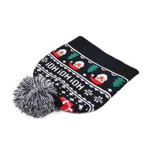 Nahaufnahme einer festlichen weihnachtlichen Strickmütze mit Nikolaus und Bommel-Detail