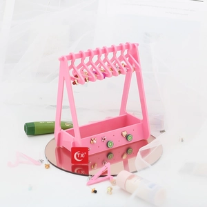 Pink acrylic jewelry stand detail featuring mini hangers and star patterned earring box
