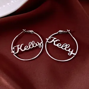 Customized silver Kelly name hoop earrings with personalized script on red satin background