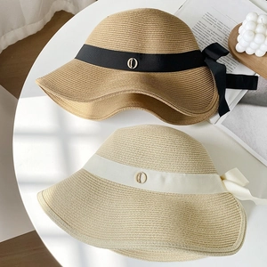 Straw sun hats with bow ribbons and metallic buckles shown in a top-down view