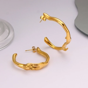 Boucles d'oreilles créoles C en acier inoxydable doré avec un design unique de mains tenues