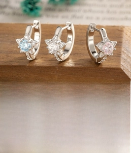 Detail of star-shaped hoop earrings with blue, white and pink cubic zirconia stones