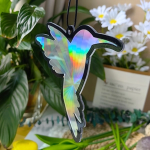 Close-up of laser rainbow hummingbird suncatcher with black frame and hanging rope