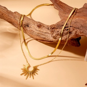 Double-layered gold stainless steel necklace featuring a sunburst pendant on a rustic branch
