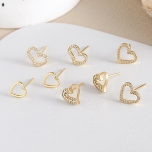 Luxury heart-shaped gold stud earrings set featuring sparkling crystals and polished finish