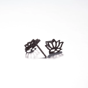 Macro shot of matte black hollowed-out lotus flower stud earrings in stainless steel