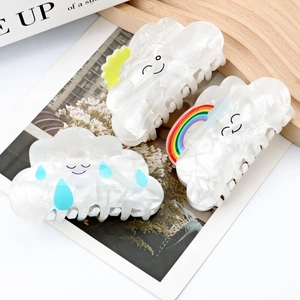 Set of three cloud-shaped hair claws with rainbow and sun patterns in pearly white