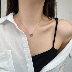 Close-up of a square cut blue zircon pendant on a silver S925 necklace worn on neck