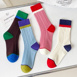 Flat lay detail of four pairs of ribbed color-block cotton socks in retro vibrant tones