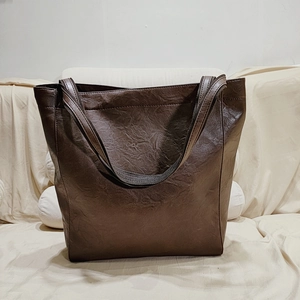 Vue détaillée du grand sac cabas vintage en cuir marron foncé avec texture naturelle