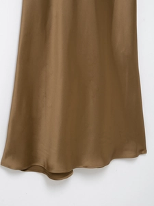 Detailed close-up showing the elegant glossy brown satin fabric and hem of the long dress