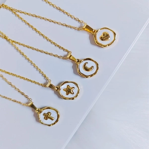 Minimalist gold-plated necklaces with heart, moon, star, and cross relief on white enamel