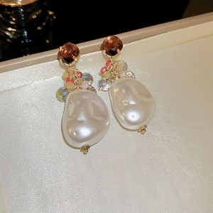 Detail of vintage baroque pearl earrings with brown crystal and colorful beads on satin