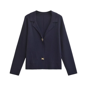 Close-up of golden bee-shaped buttons on navy blue knitted cardigan for women