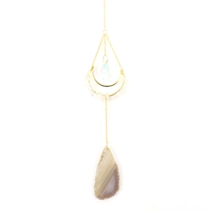 Detail of moon-shaped frame with colorful agate slices and clear crystal pendants