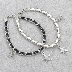 Close-up of black and white braided friendship bracelets with magnetic heart star charms