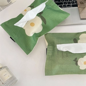 Close-up of green floral linen fabric tissue cover with elastic straps and woven texture
