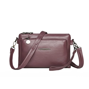 Fashionable purple faux leather crossbody bag with multiple zip pockets and metal decor