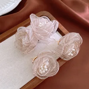 Elegant champagne mesh flower earrings with pearls and gold base in a vintage tray